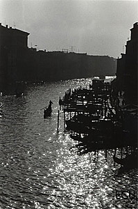 Black and white photo of the Grand Canal and gondolier from the Ponte Rialto in Venice, Italy