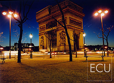 Color photo of the Arc de Triomph in Paris taken at dusk from the north side of Etoile in winter in France